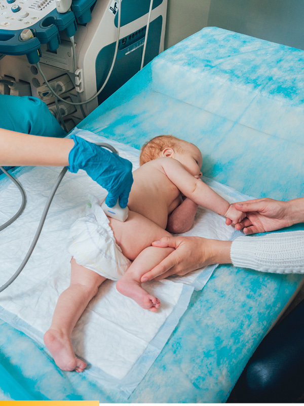 Un bébé sur le côté se fait tester avec un échographe portable